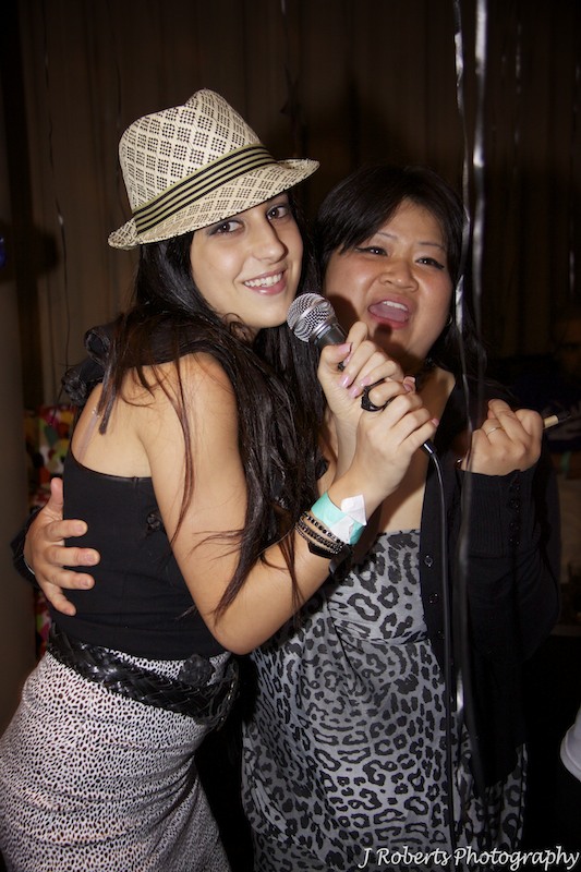 Couple singing karaoke at party - party photography